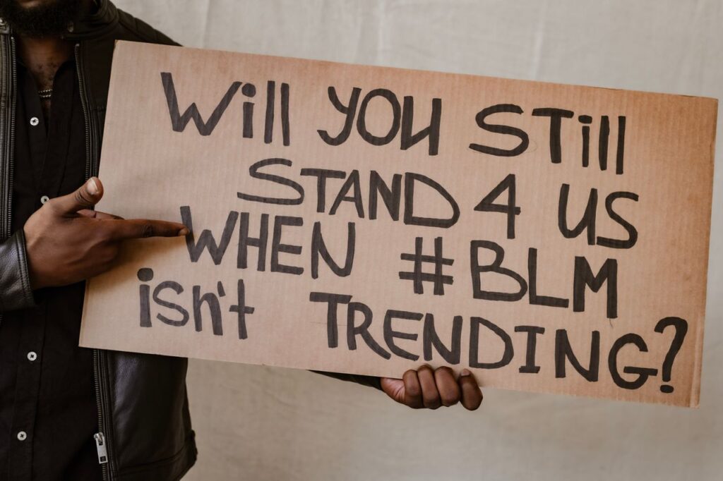 Close-up of a protest sign asking for support for BLM beyond trending topics, diversity focus.